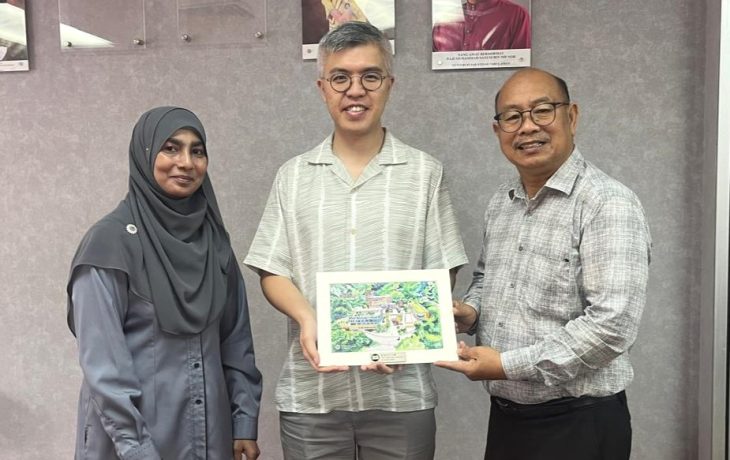 Dr Azahar Kasim from the UUM Centre for International Affairs and Cooperation, and Dr Ken Yau, Head of Global Affairs exchange souvenirs.