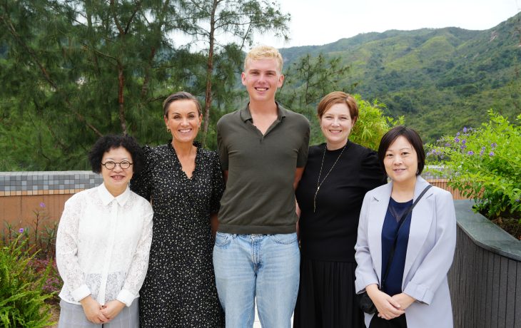 UiA 學生 Tobias Holth（中）向代表團介紹香港恒生大學賽馬會住宿書院頂層的花園景觀。