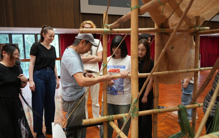 The facilitator demonstrates the technique of bamboo scaffolding to the students.